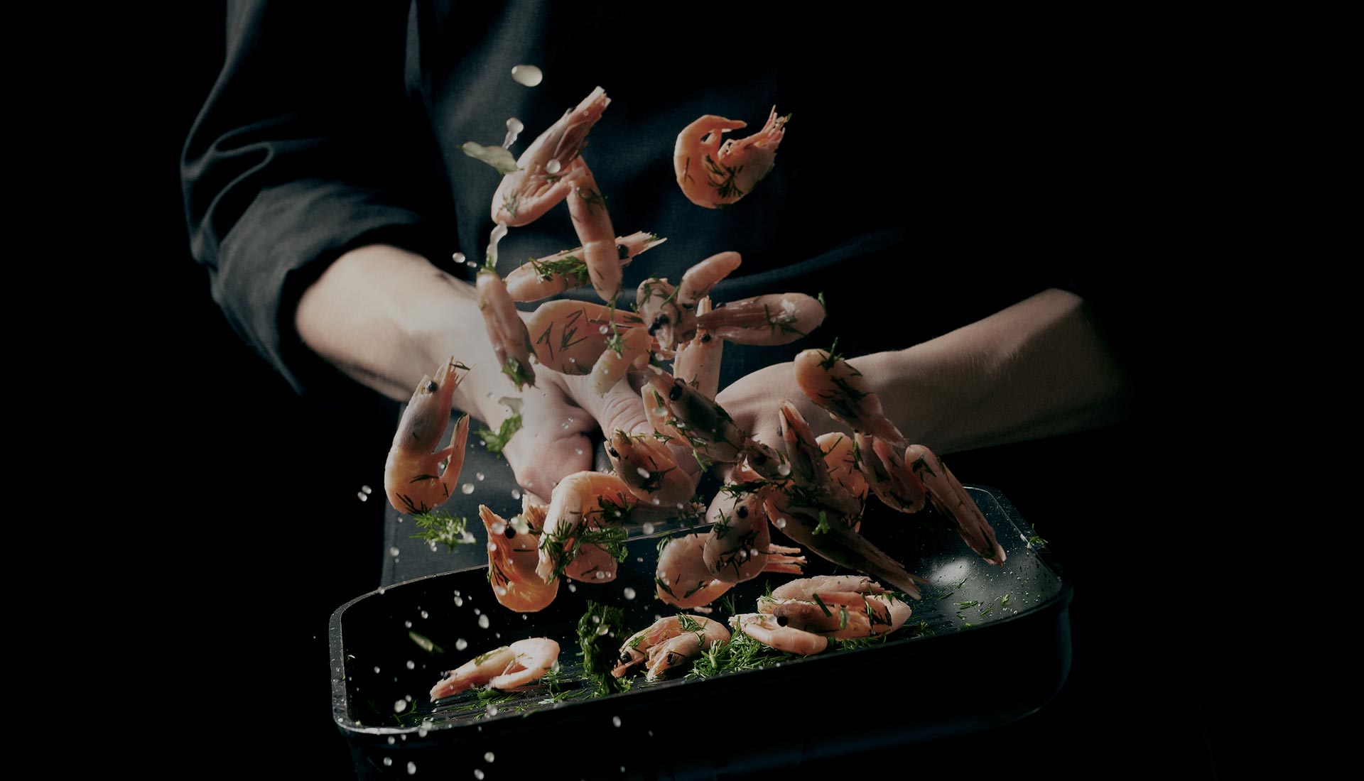 Photo of chef tossing shrimp in a bowl